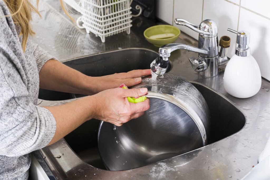 Donna che sciacqua la pentola