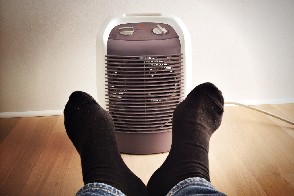 Scaldare i piedi davanti al termoventilatore