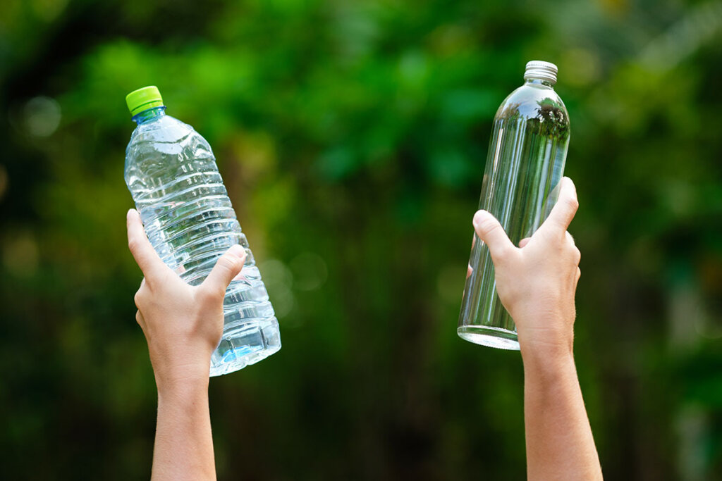 mani_che_tengono_bottiglia_di_plastica_e_vetro_alta