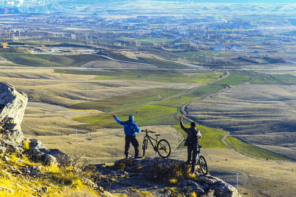 ciclista in piedi su una montagna che osserva il paesaggio