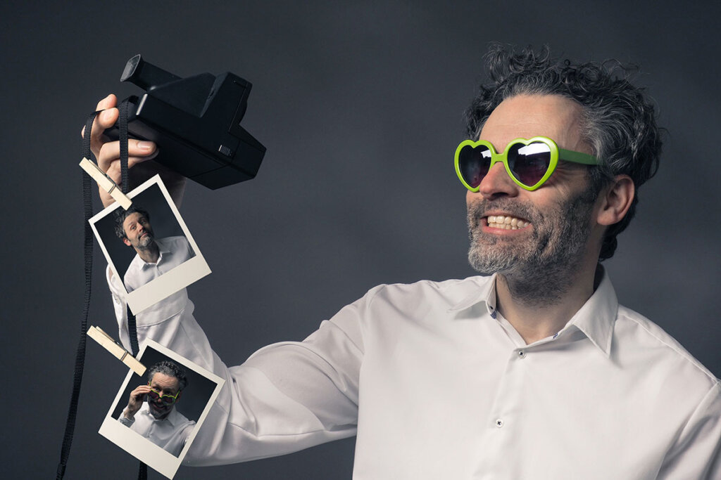 uomo con macchina fotografica istantanea scatta selfie