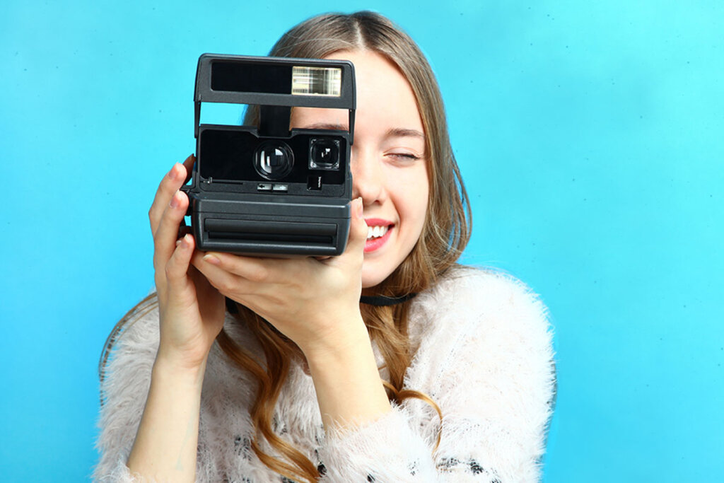 donna scatta foto con una macchina fotografica istantanea