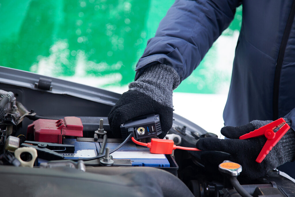 L'uomo collega l'avviatore di emergenza alla batteria dell'auto