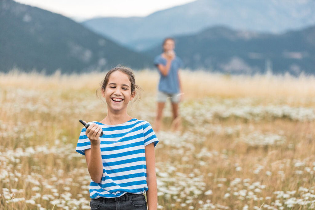 Due fratelli che giocano con un walkie-talkie all'aperto