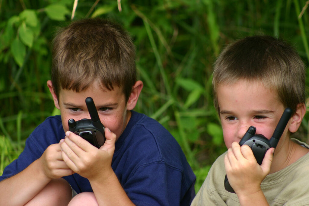 Due ragazzi che giocano con i walkie-talkie all'aperto