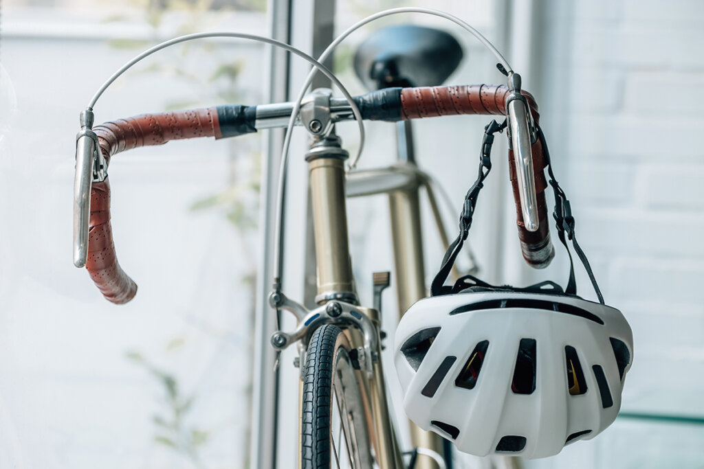 Casco da bicicletta sul manubrio di una bici da corsa