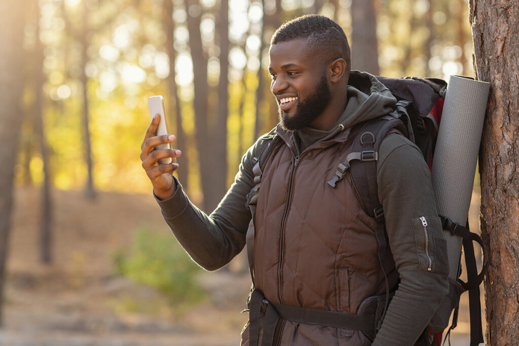 Uomo nella foresta che guarda lo smartphone